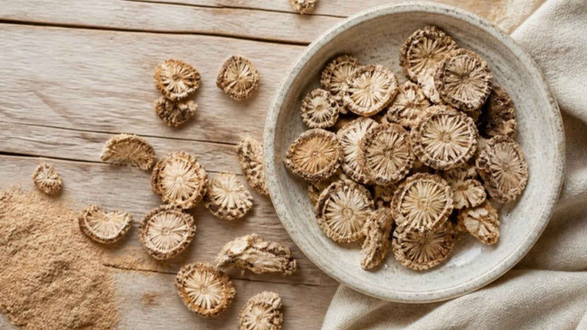 Getrocknete Scheiben der Teufelskralle-Wurzelknolle in einer Schale und auf dem Holztisch, mit feinem Sand